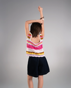 Person wearing a colorful striped tank top and black shorts on a gray background