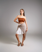Woman wearing a strapless top and skirt with a textured pattern on a gray background