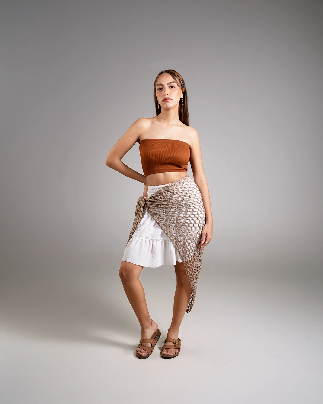 Woman wearing a strapless top and skirt with a textured pattern on a gray background