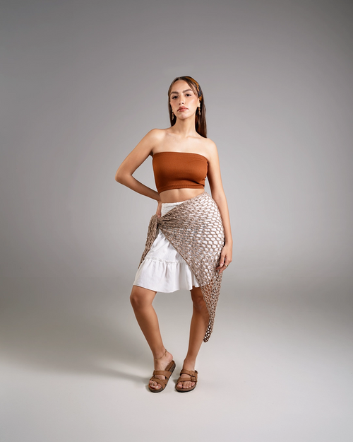 Woman wearing a strapless top and skirt with a textured pattern on a gray background