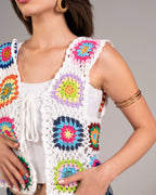 Colorful crochet vest over a white top on a neutral background