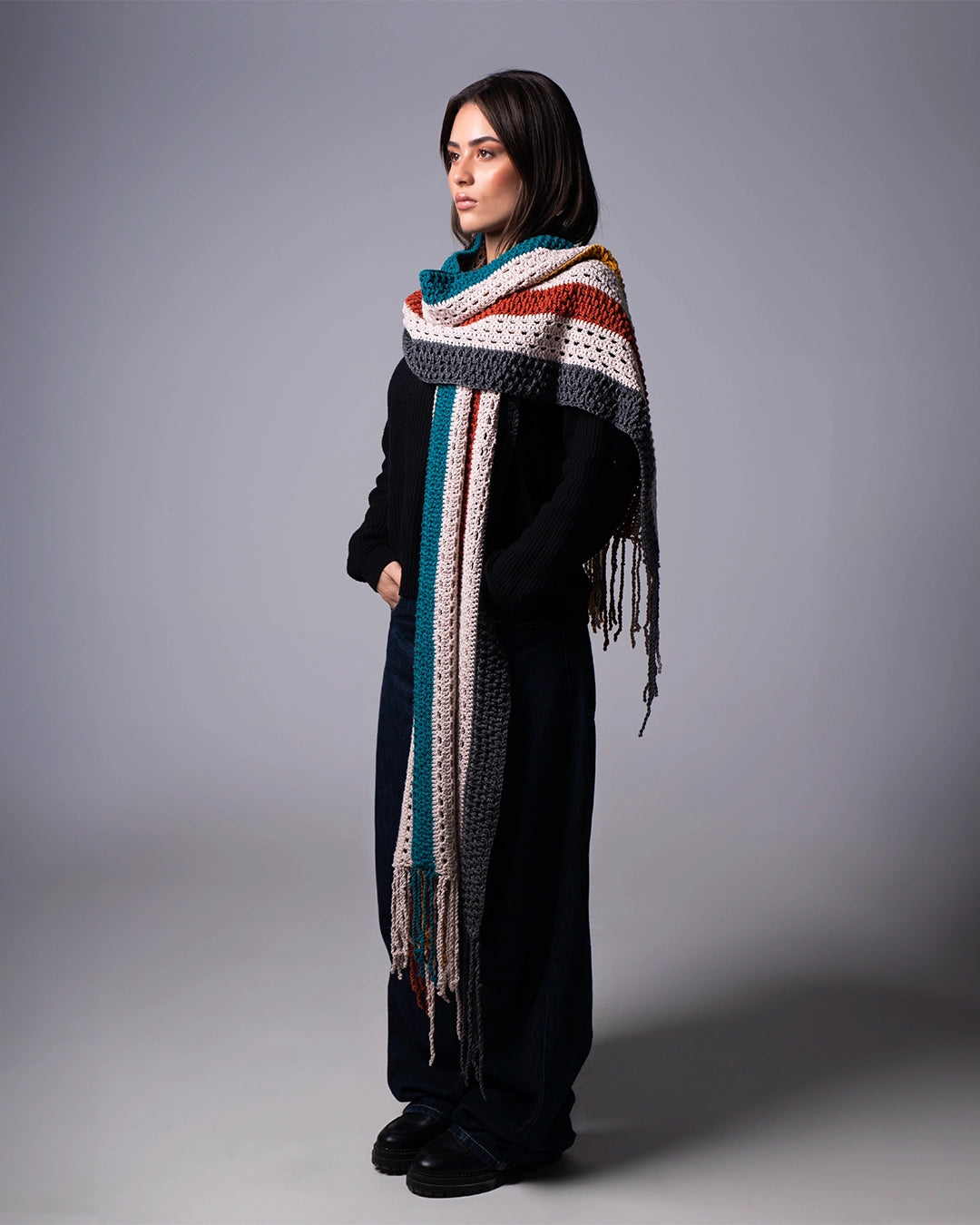 Woman wearing a colorful scarf on a gray background