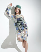 Person wearing a colorful crochet dress on a plain background