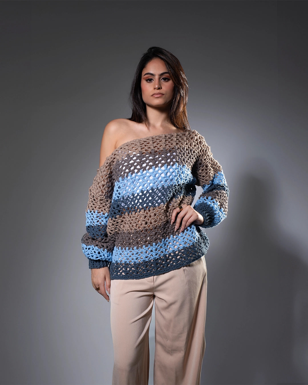 Woman wearing a patterned sweater against a gray background