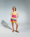 Woman wearing a colorful striped dress against a gray background