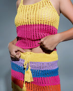 Colorful crochet top and skirt set on a gray background